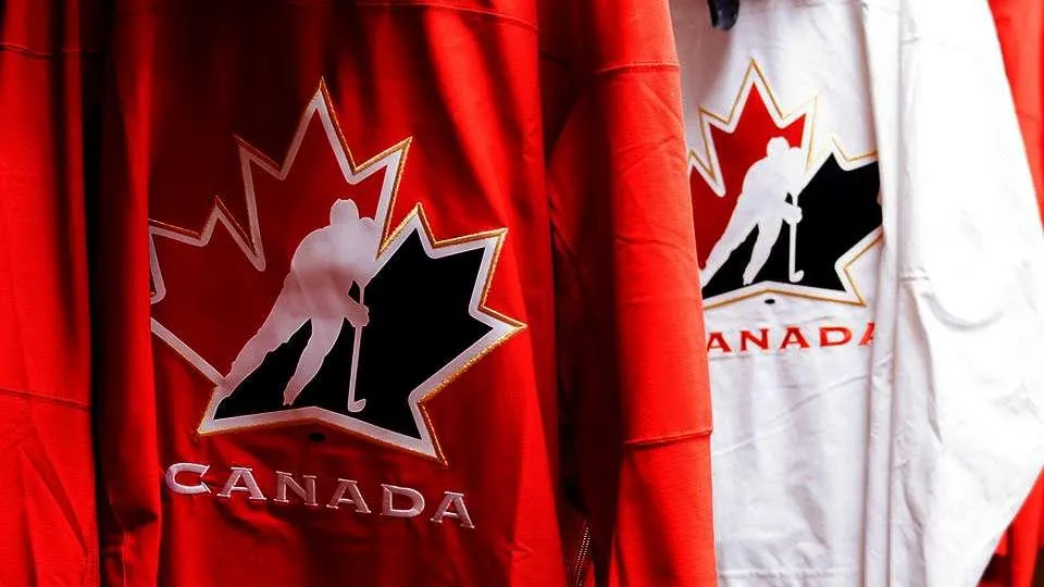 Two Team Canada Jerseys hanging beside each other, one home and one away.