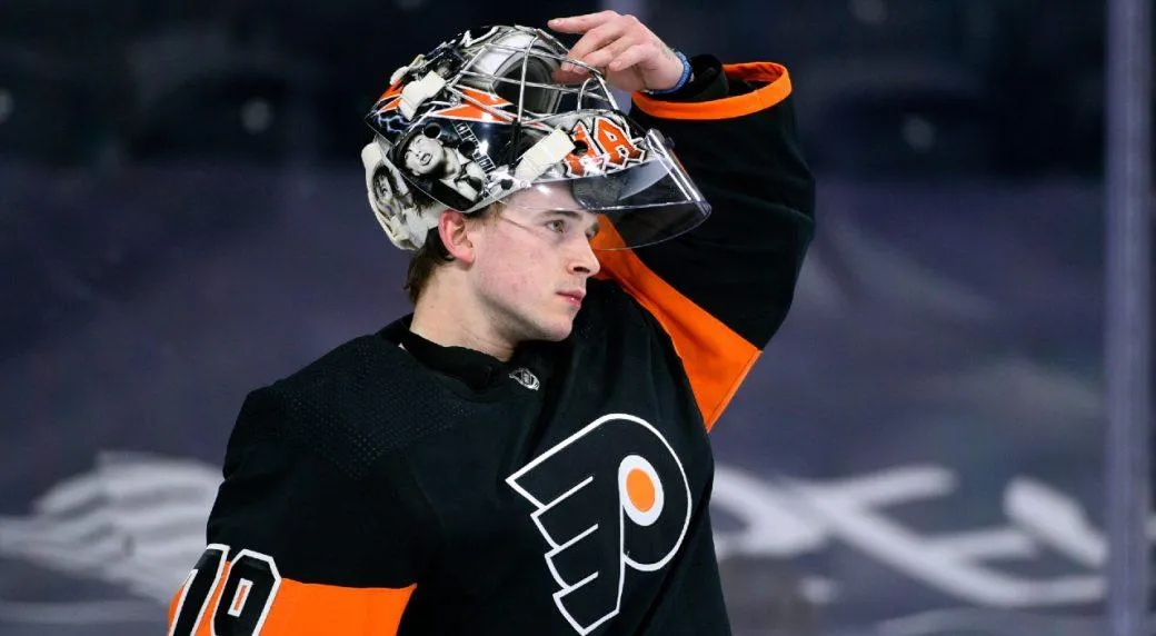 Carter Hart, goaltender for the Philadelphia Flyers, lifting his mask up during a game.