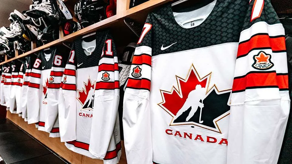 Team Canada Jerseys (White) hanging in a locker room prior to a game.