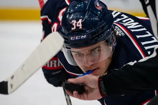 Cole Sillinger of the Columbus Blue Jackets taking a faceoff during an NHL game.
