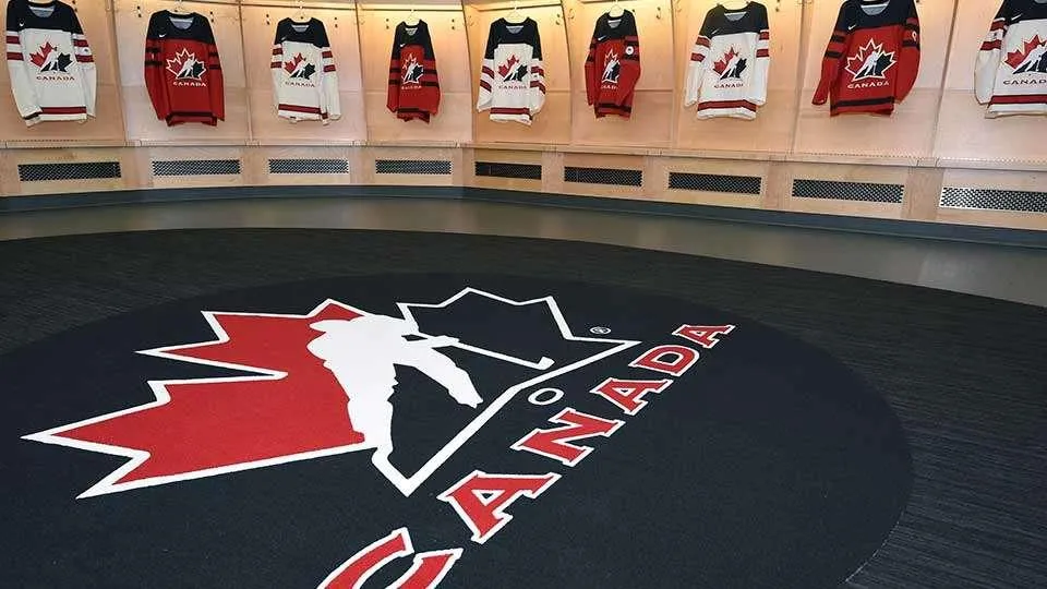 Team Canada dressing room with various Hockey Canada jerseys hanging from the stalls.