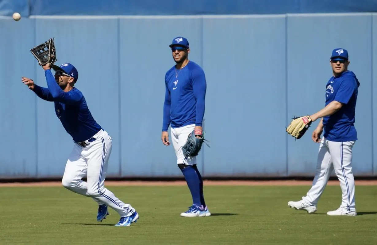 Blue Jays outfielder catch balls in practice at spring training.
