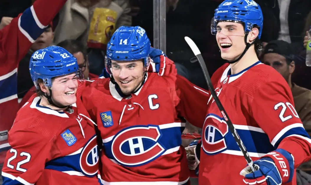 Cole Caufield, Nick Suzuki et Juraj Slafkovsky célèbrent un but marqué par le capitaine.