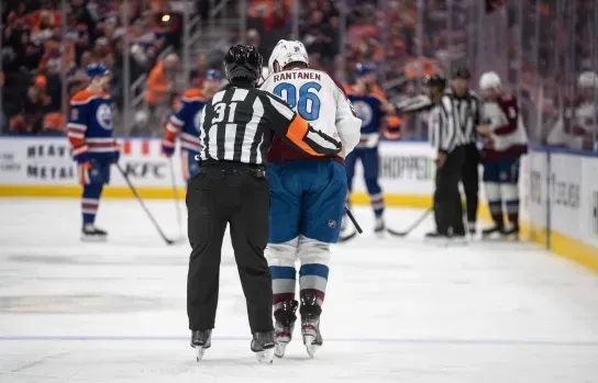 Colorado Avalanche forward Mikko Rantanen being helped by a referee to leave the ice after being injured by Mattias Ekholm in a game against the Edmonton Oilers.