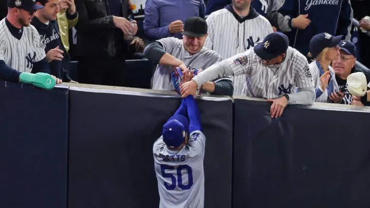 Mookie Betts of the Los Angeles Dodgers gets interfered with by New York Yankees fans