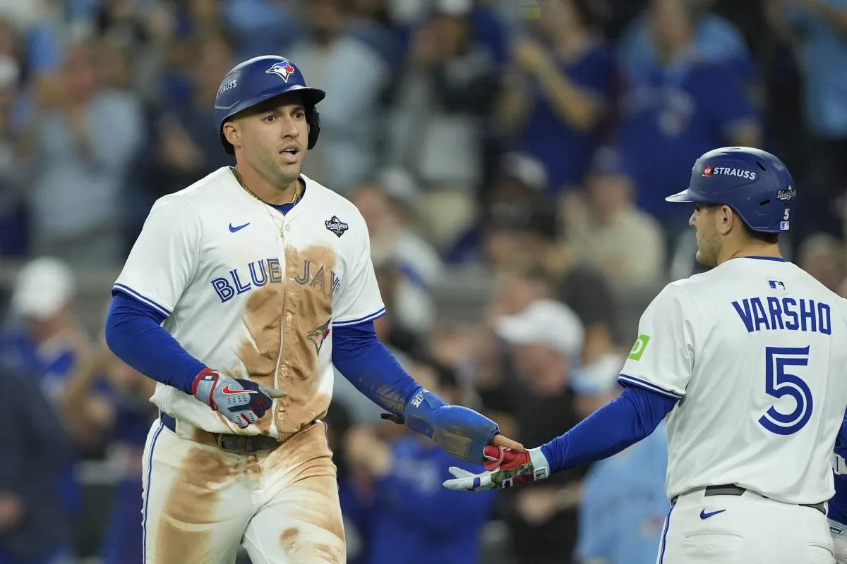 Toronto Blue Jays right fielder George Springer (4) celebrates with center fielder Daulton Varsho (5) after scoring on a sacrifice fly by catcher Alejandro Kirk (not pictured) in the third inning against the Los Angeles Dodgers during game two of the 2025 MLB World Series at Rogers Centre.