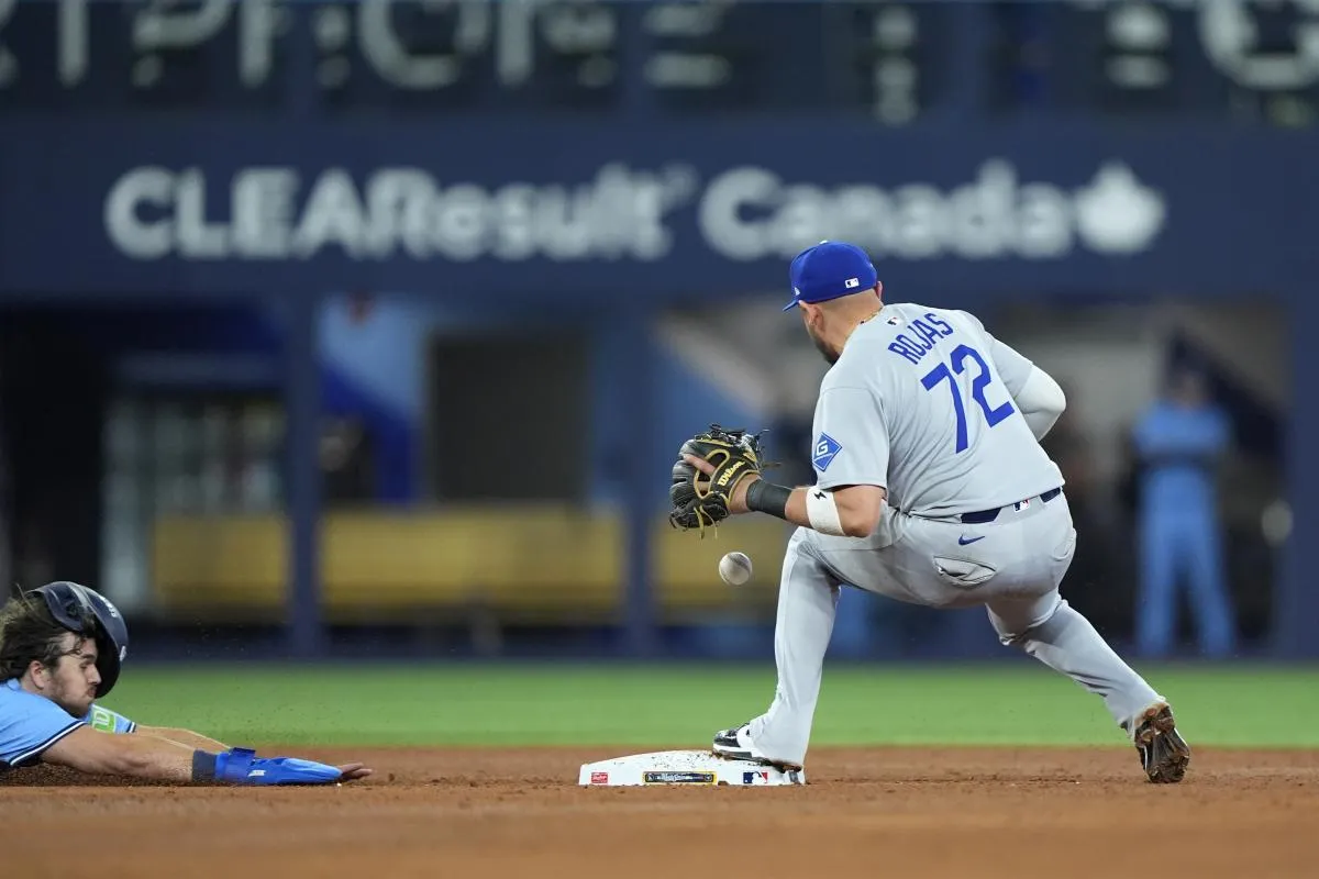 Los Angeles Dodgers second baseman Miguel Rojas (72) makes a double play against Toronto Blue Jays third baseman Addison Barger (47) in the ninth inning during game six of the 2025 MLB World Series at Rogers Centre.
