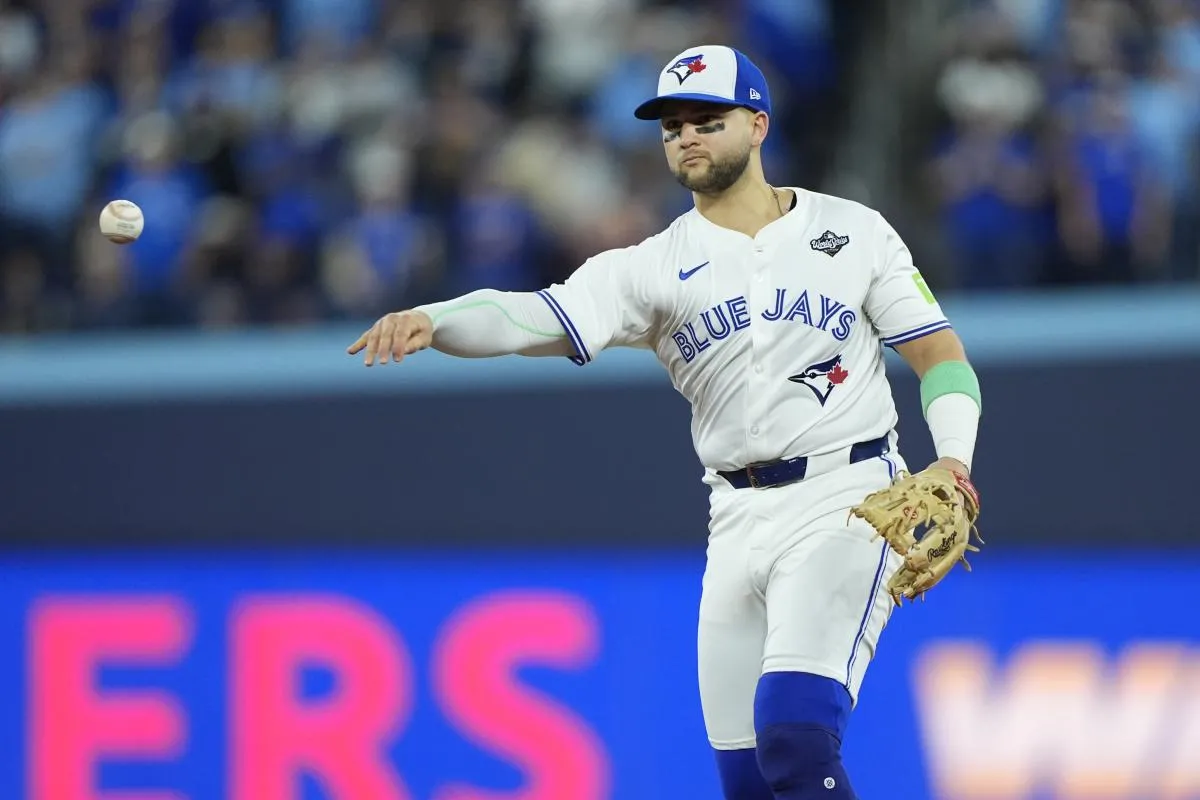 Toronto Blue Jays designated hitter Bo Bichette (11) throws to first for an out against Los Angeles Dodgers second baseman Tommy Edman (25) in the eighth inning during game seven of the 2025 MLB World Series at Rogers Centre.