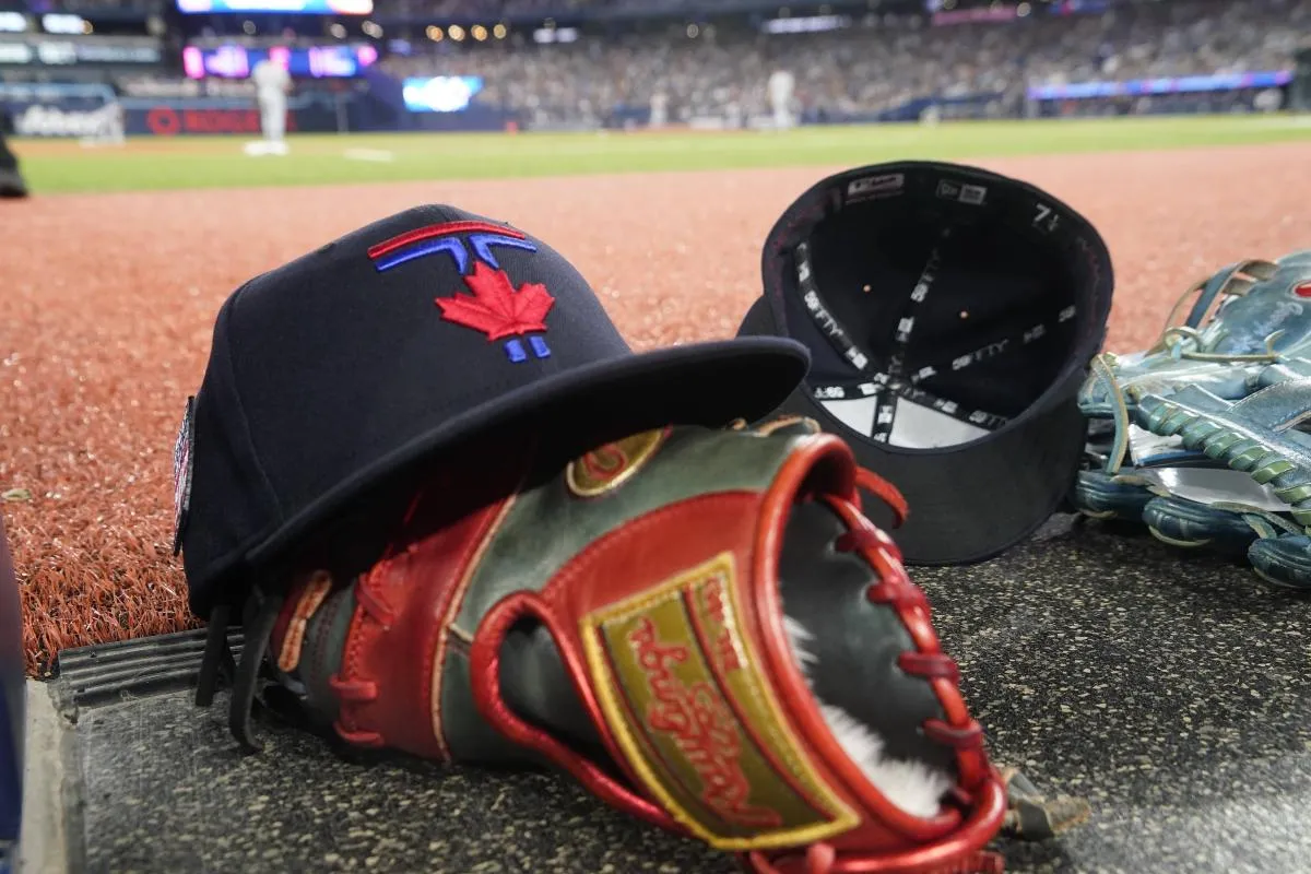 A Toronto Blue Jays hat and glove near the dugout during a game against the Detroit Tigers at Rogers Centre.