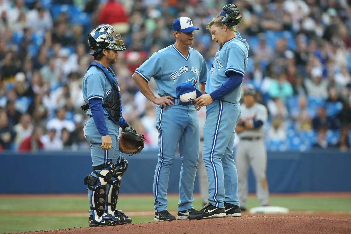 Toronto Blue Jays starting pitcher David Purcey (25) gets a visit to the mound from picthing coach Brad Arnsberg (38) and catcher Gregg Zaun (9) against the Detroit Tigers at the Rogers Centre in Toronto, ON.