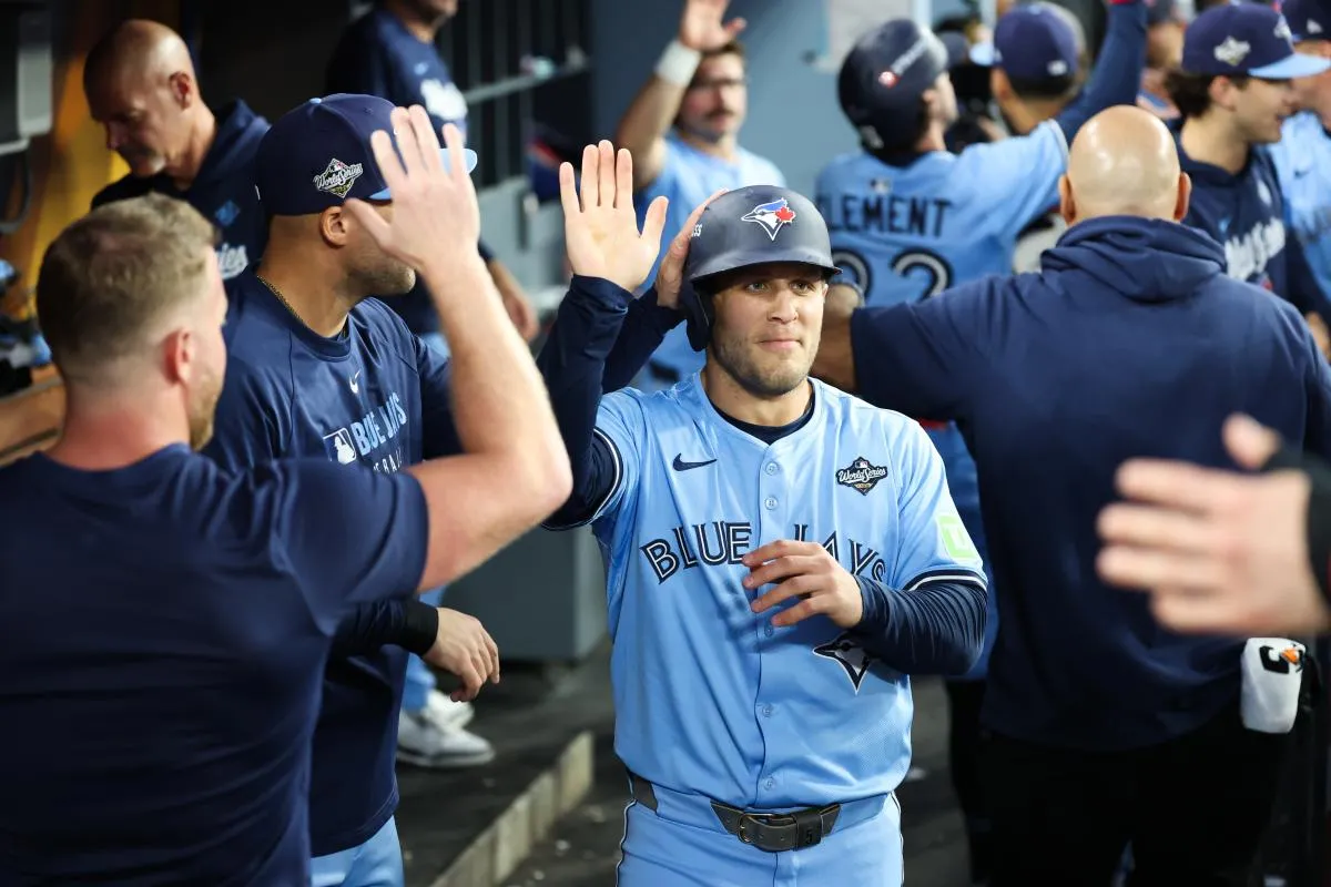 Toronto Blue Jays center fielder Daulton Varsho (5) celebrates in the dugout after scoring during the fourth inning against the Los Angeles Dodgers during game five of the 2025 MLB World Series at Dodger Stadium.
