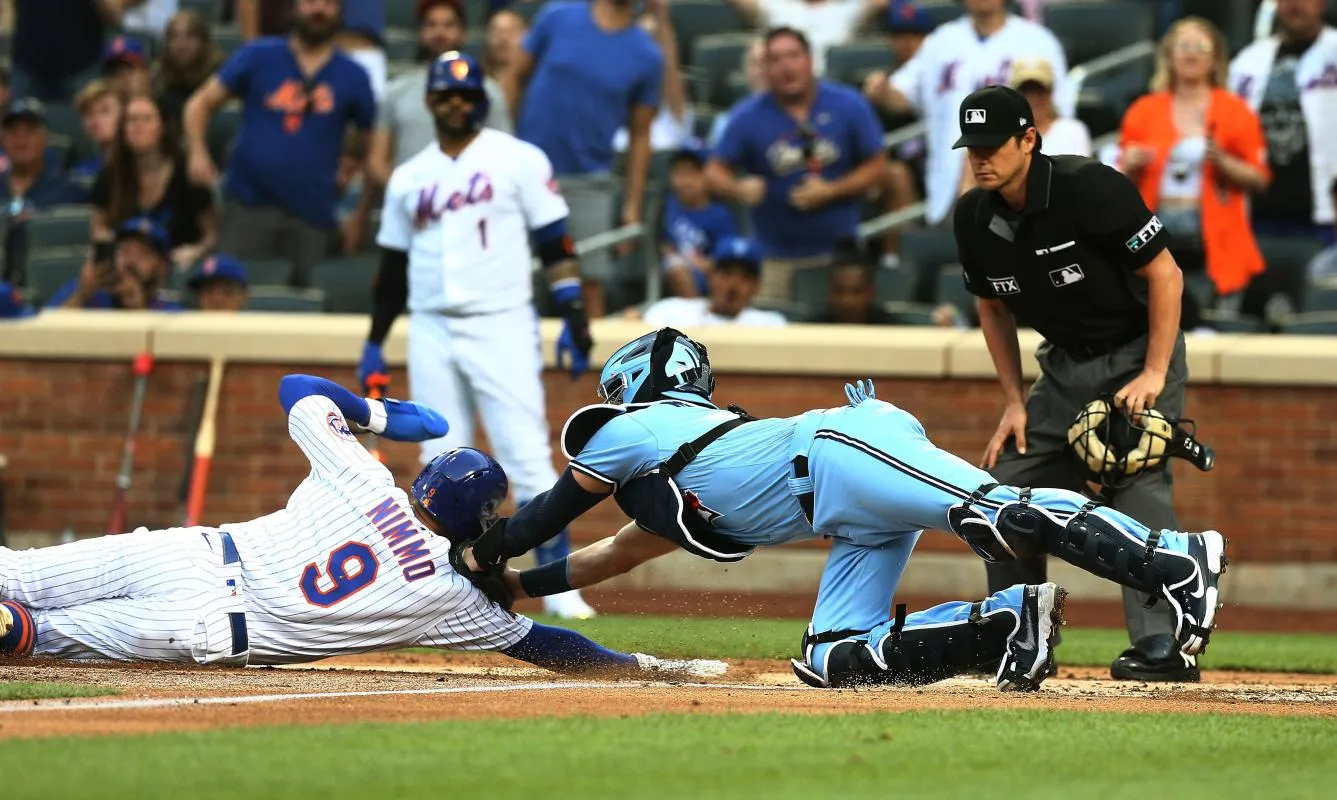 New York Mets center fielder Brandon Nimmo (9) is tagged out at home by Toronto Blue Jays catcher Reese McGuire (7) trying to score during the first inning at Citi Field.