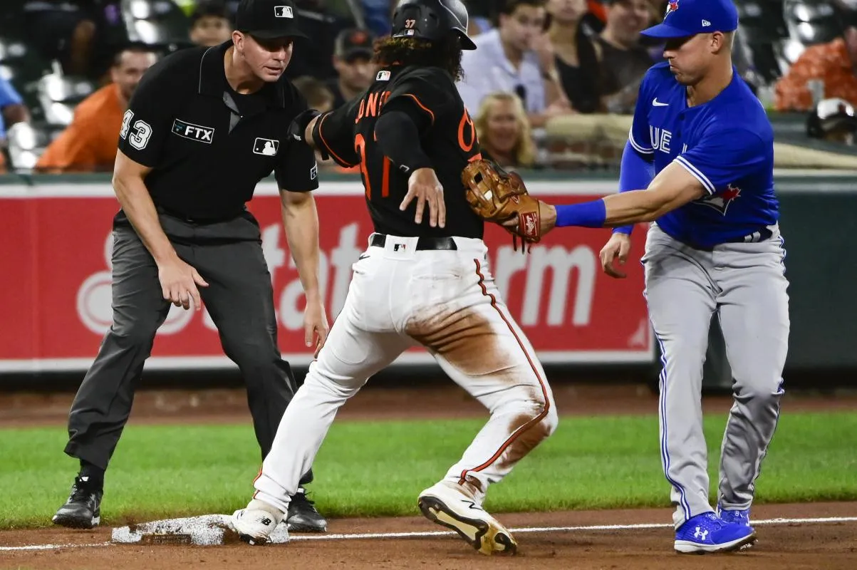 Toronto Blue Jays third baseman Jake Lamb (2) applies the tag on Baltimore Orioles second baseman Jahmai Jones (37) as third base umpire Shane Livensparger (43) looks on at Oriole Park at Camden Yards.