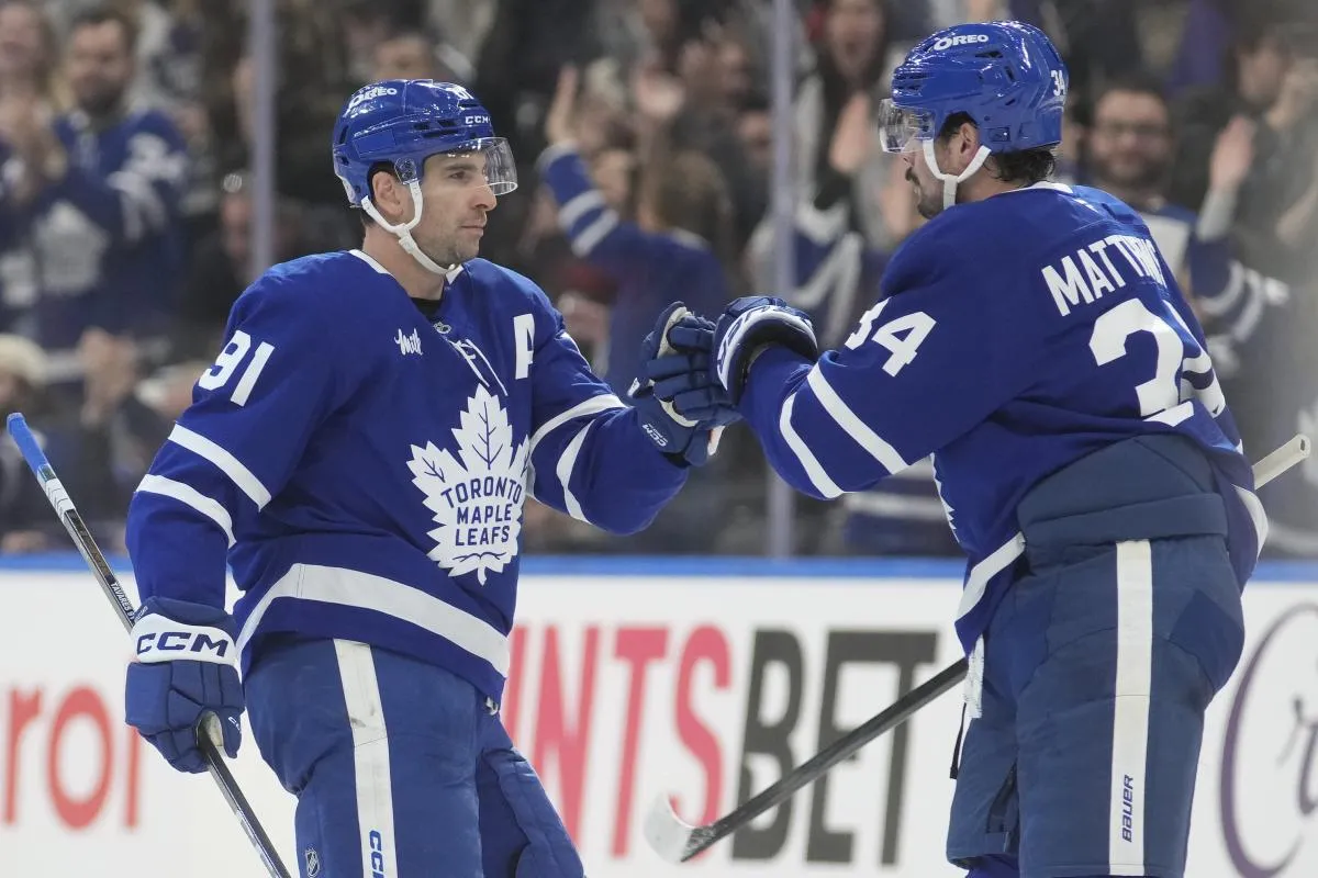 Toronto Maple Leafs forward Auston Matthews (34) congratulates forward John Tavares (91) for scoring an empty net goal against the Ottawa Senators during the third period at Scotiabank Arena.
