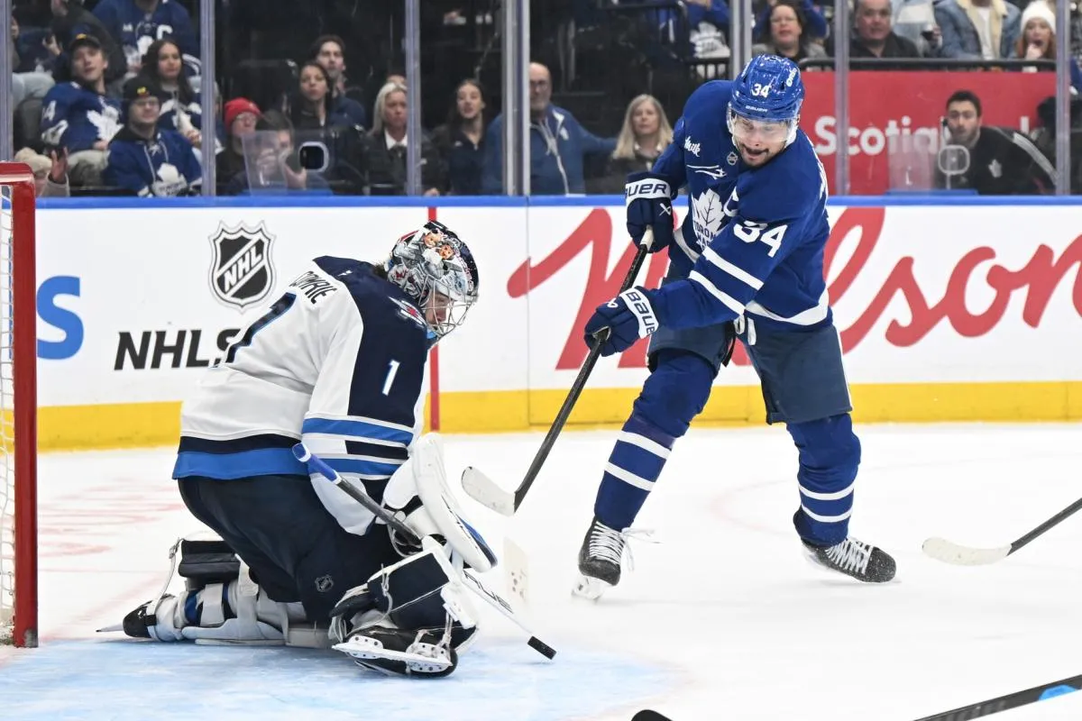 Winnipeg Jets goalie Eric Comrie (1) makes a save on a shot from Toronto Maple Leafs forward Auston Matthews (34) in the third period at Scotiabank Arena.