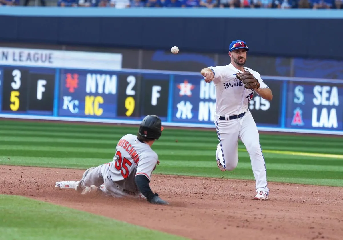 Toronto Blue Jays shortstop Paul DeJong (10) tags out Baltimore Orioles catcher Adley Rutschman (35) at second base during the eighth inning at Rogers Centre.