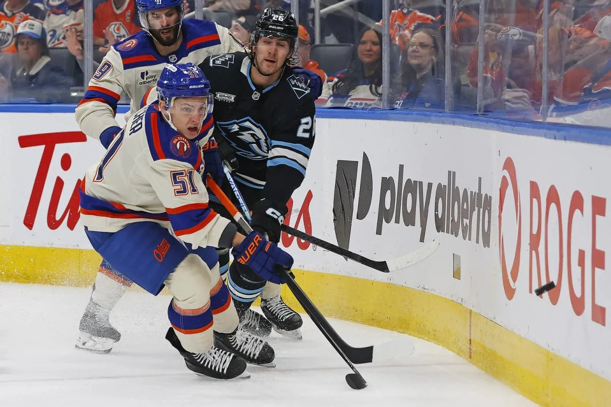 Edmonton Oilers defensemen Troy Stecher (51) moves the puck in front of Utah Mammoth defensemen Dmitri Simashev (26) during the second period at Rogers Place.