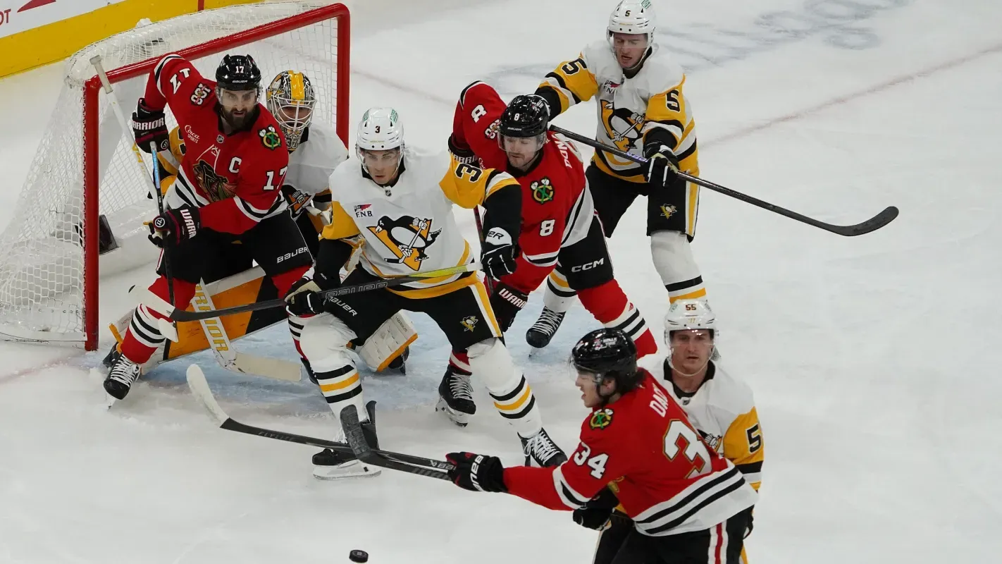 Pittsburgh Penguins and Chicago Blackhawks players battle in front of the net