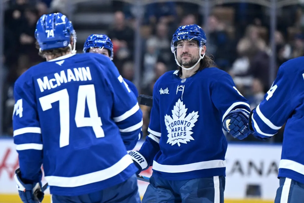 Toronto Maple Leafs defenseman Chris Tanev (8) greets forward Bobby McMann who scored an empty net goal against the Pittsburgh Penguins in the third period at Scotiabank Arena.