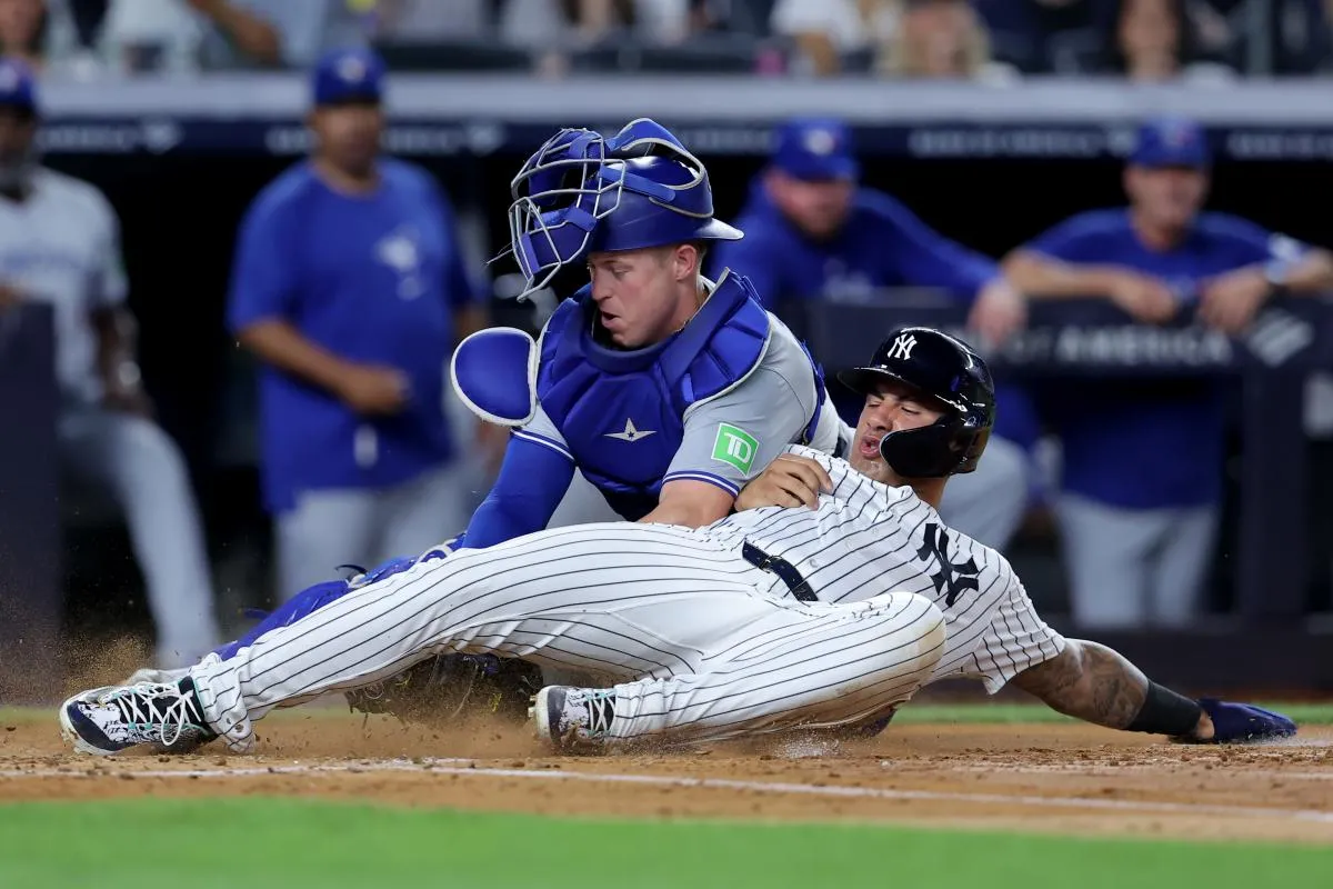 Toronto Blue Jays catcher Brian Serven (15) tags out New York Yankees second baseman Gleyber Torres (25) trying to score from first on a base hit by Yankees shortstop Anthony Volpe (not pictured) during the second inning at Yankee Stadium.