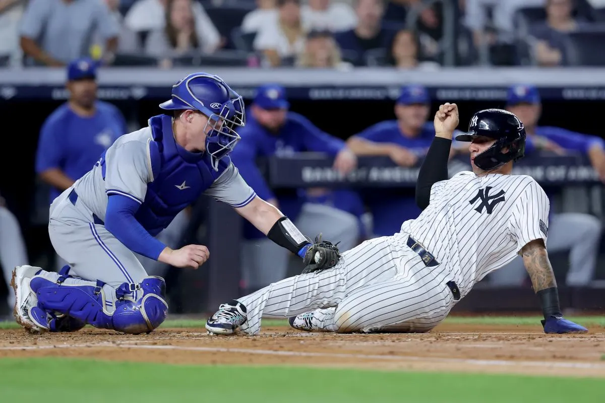 Toronto Blue Jays catcher Brian Serven (15) tags out New York Yankees second baseman Gleyber Torres (25) trying to score on a base hit by Yankees shortstop Anthony Volpe (not pictured) during the second inning at Yankee Stadium.