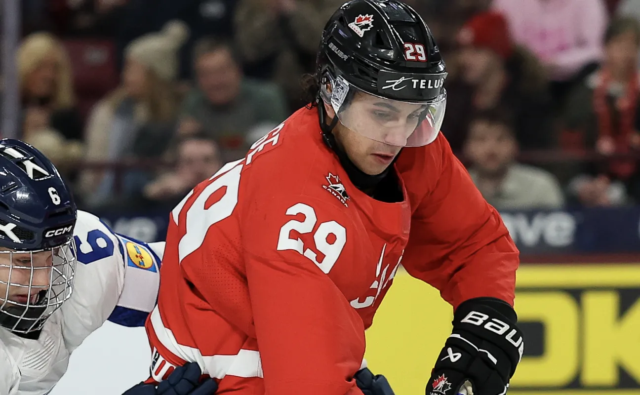 L'attaquant canadien Michael Hage (29) patine avec le palet tandis que le d&eacute;fenseur finlandais Juho Piiparinen (6) d&eacute;fend pendant la deuxi&egrave;me p&eacute;riode du match de groupe lors du Championnat mondial junior 2026 de l'IIHF &agrave; la 3M Arena.