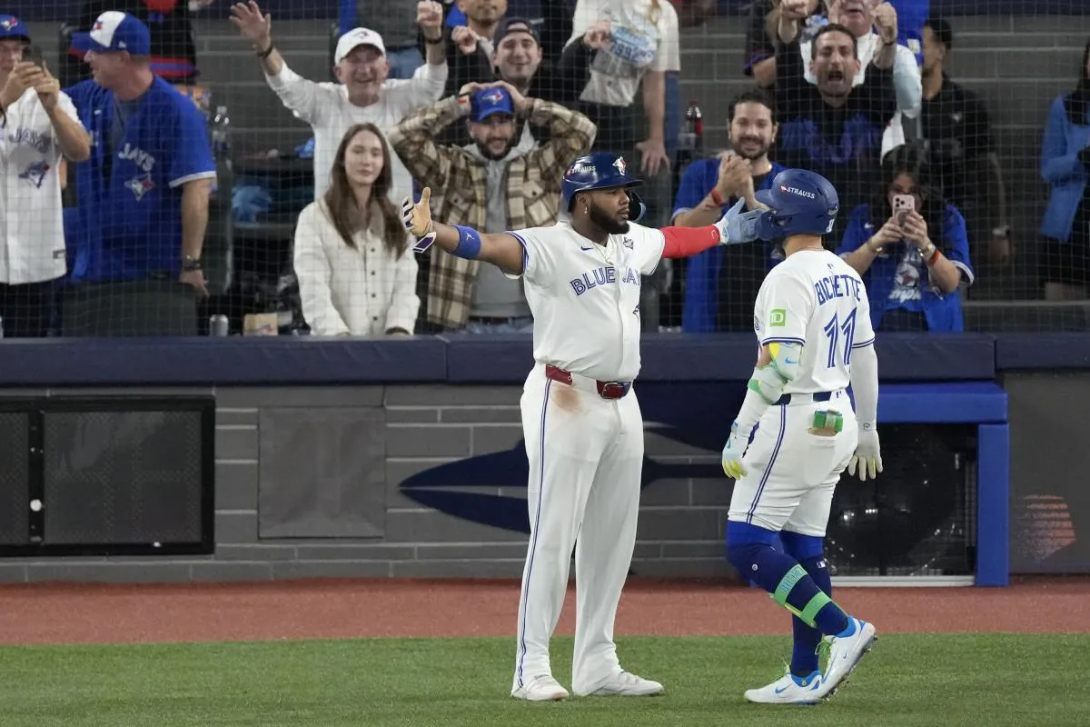 Toronto Blue Jays designated hitter Bo Bichette (11) celebrates with first baseman Vladimir Guerrero Jr. (27) after hitting a three run home run against the Los Angeles Dodgers in the third inning during game seven of the 2025 MLB World Series at Rogers Centre