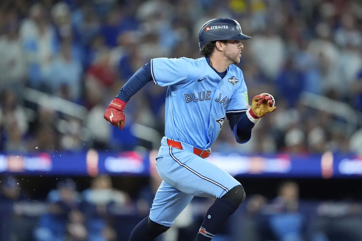 Toronto Blue Jays third baseman Ernie Clement (22) runs to first after hitting a single against the Los Angeles Dodgers in the fifth inning during game six of the 2025 MLB World Series at Rogers Centre.