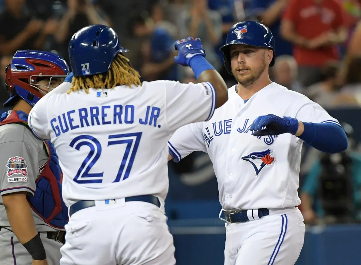 Toronto Blue Jays designated hitter Justin Smoak (14) is greeted at home plate by third baseman Vladimir Guerrero Jr. (27) after hitting a two run home run against Texas Rangers in the third inning at Rogers Centre