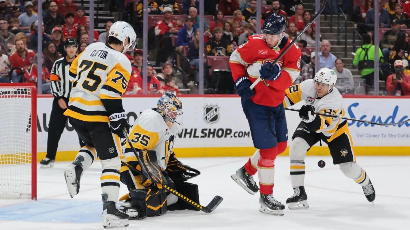 Florida Panthers center Eetu Luostarinen (27) shoots the puck against Pittsburgh Penguins goaltender Tristan Jarry (35) as defenseman Connor Clifton (75) and defenseman Caleb Jones (82) defend during the second period at Amerant Bank Arena.