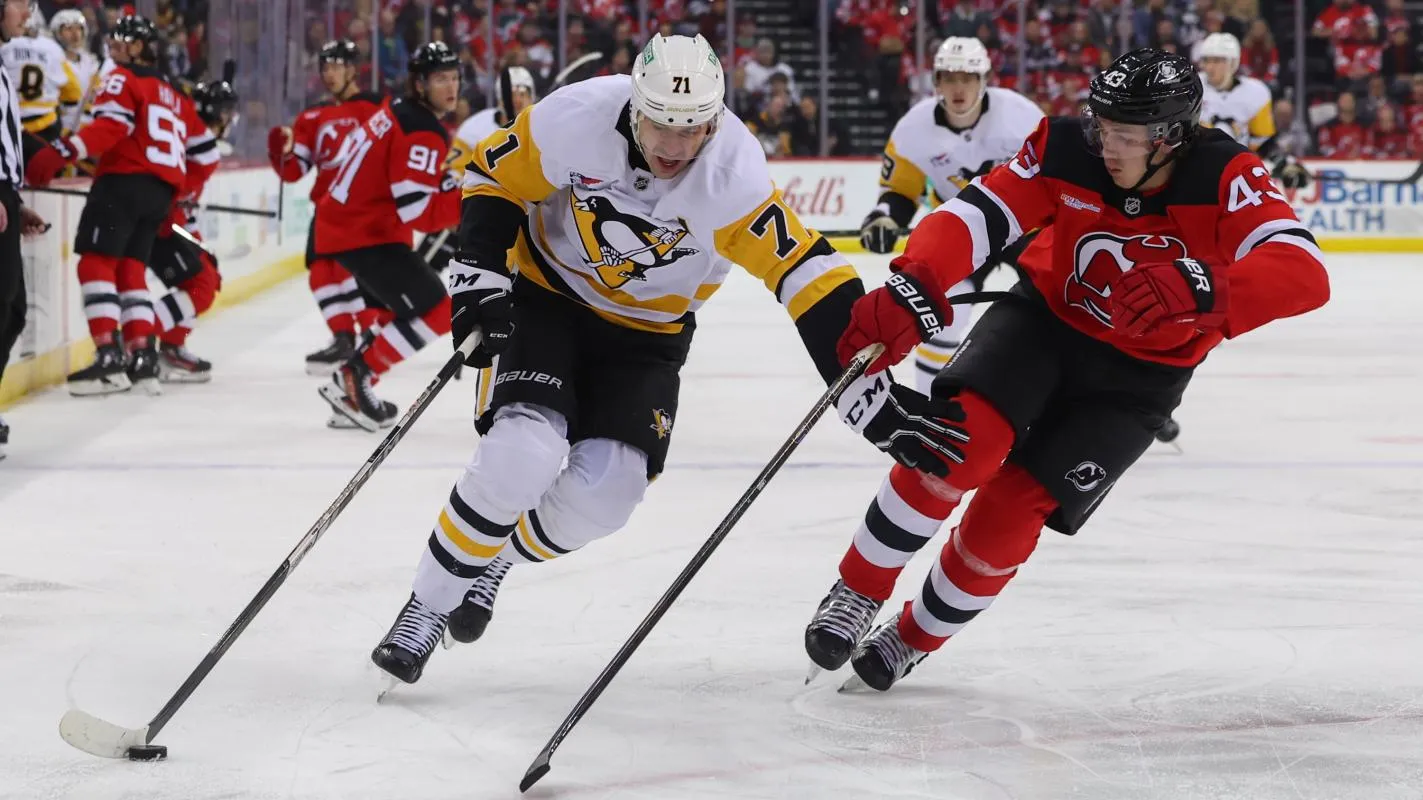 Pittsburgh Penguins center Evgeni Malkin (71) skates with the puck while being defended by New Jersey Devils defenseman Luke Hughes (43) during the first period at Prudential Center.