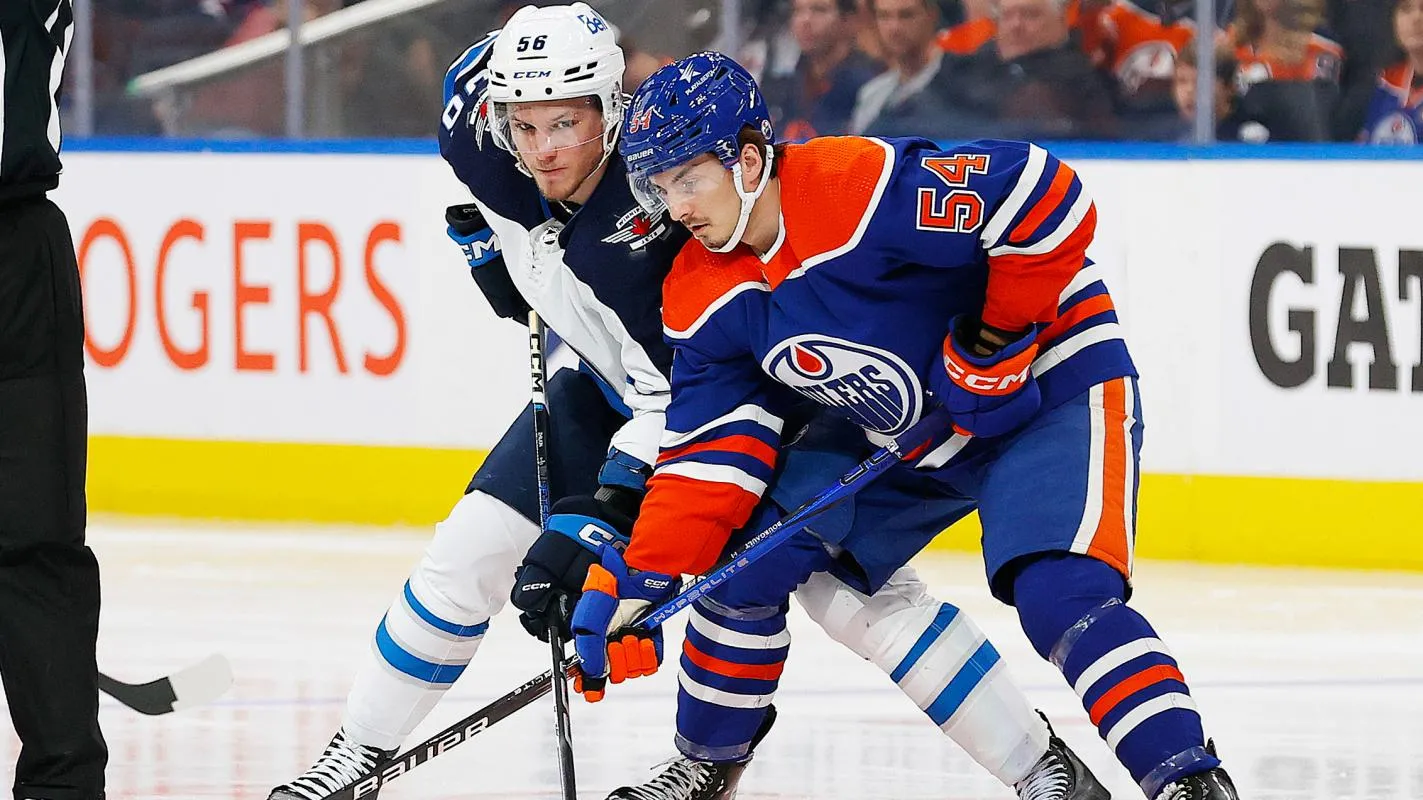 Edmonton Oilers forward Xavier Bourgault (54) and Winnipeg Jets forward Danny Zhilkin (56) look for a loose puck during the second period at Rogers Place.