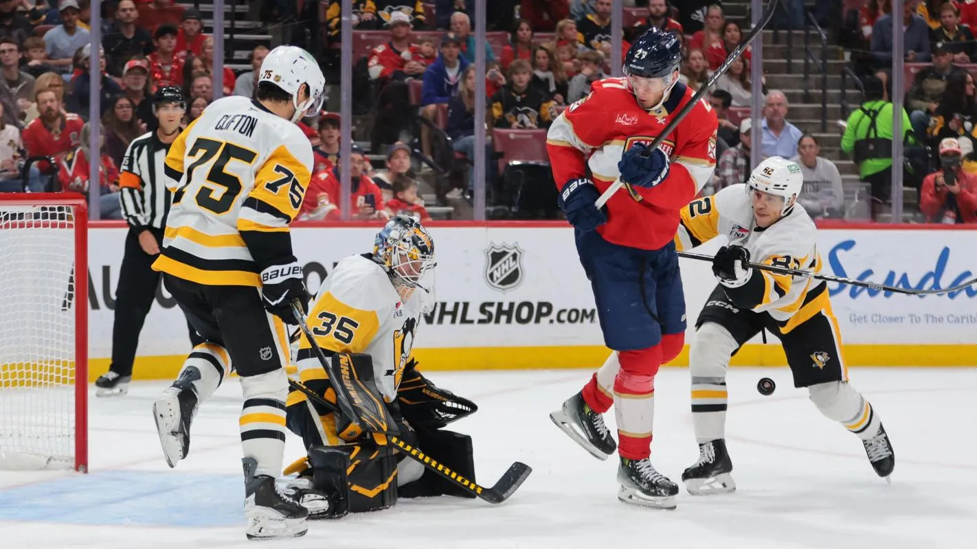 Florida Panthers center Eetu Luostarinen (27) shoots the puck against Pittsburgh Penguins goaltender Tristan Jarry (35) as defenseman Connor Clifton (75) and defenseman Caleb Jones (82) defend during the second period at Amerant Bank Arena.