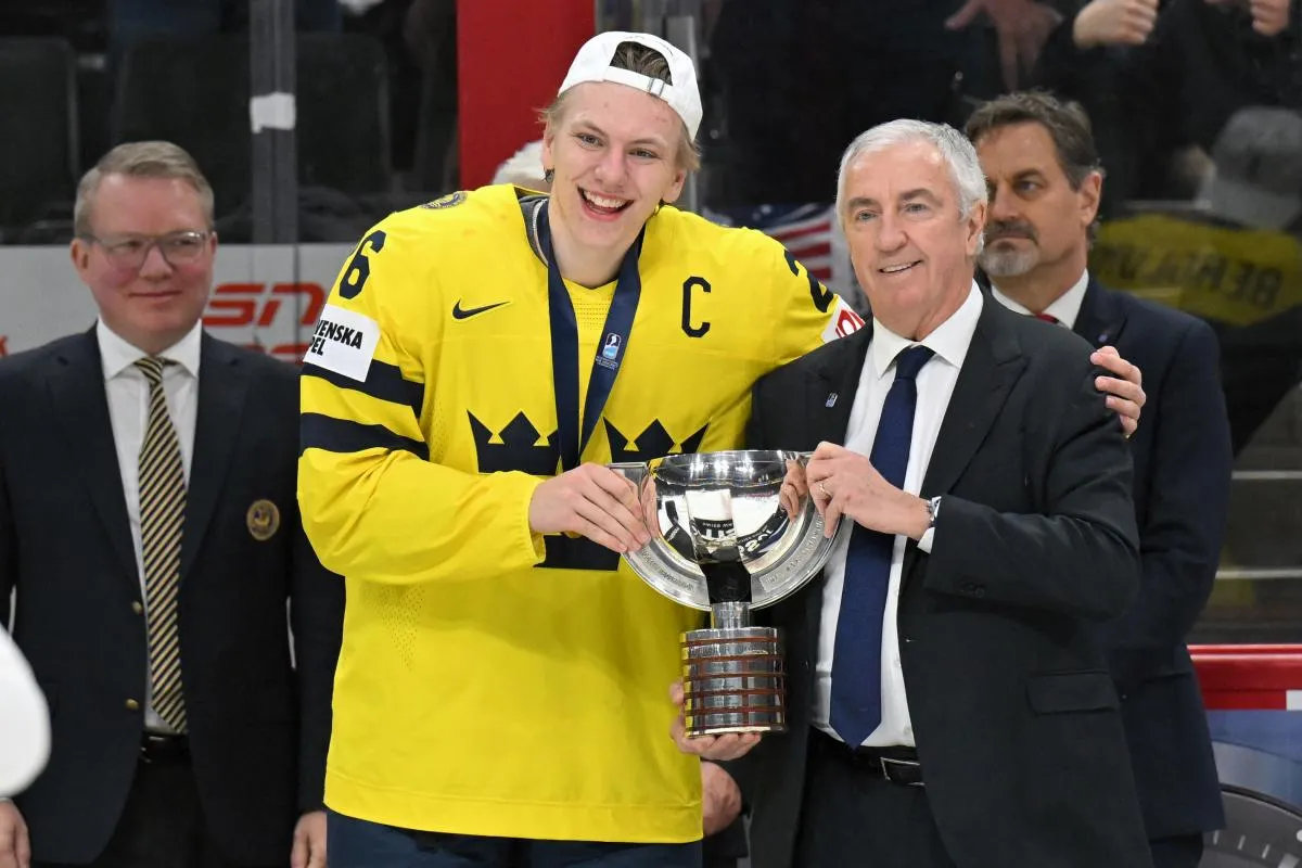 Sweden forward Jack Berglund (26) is presented with the first-place trophy by IIHF President Luc Tardif after defeating Czechia in the final of the 2026 IIHF World Junior Championship ice hockey tournament at Grand Casino Arena.