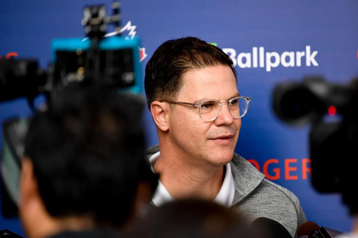 Toronto Blue Jays general manager Ross Atkins (glasses) is interviewed during spring training at Spectrum Field.