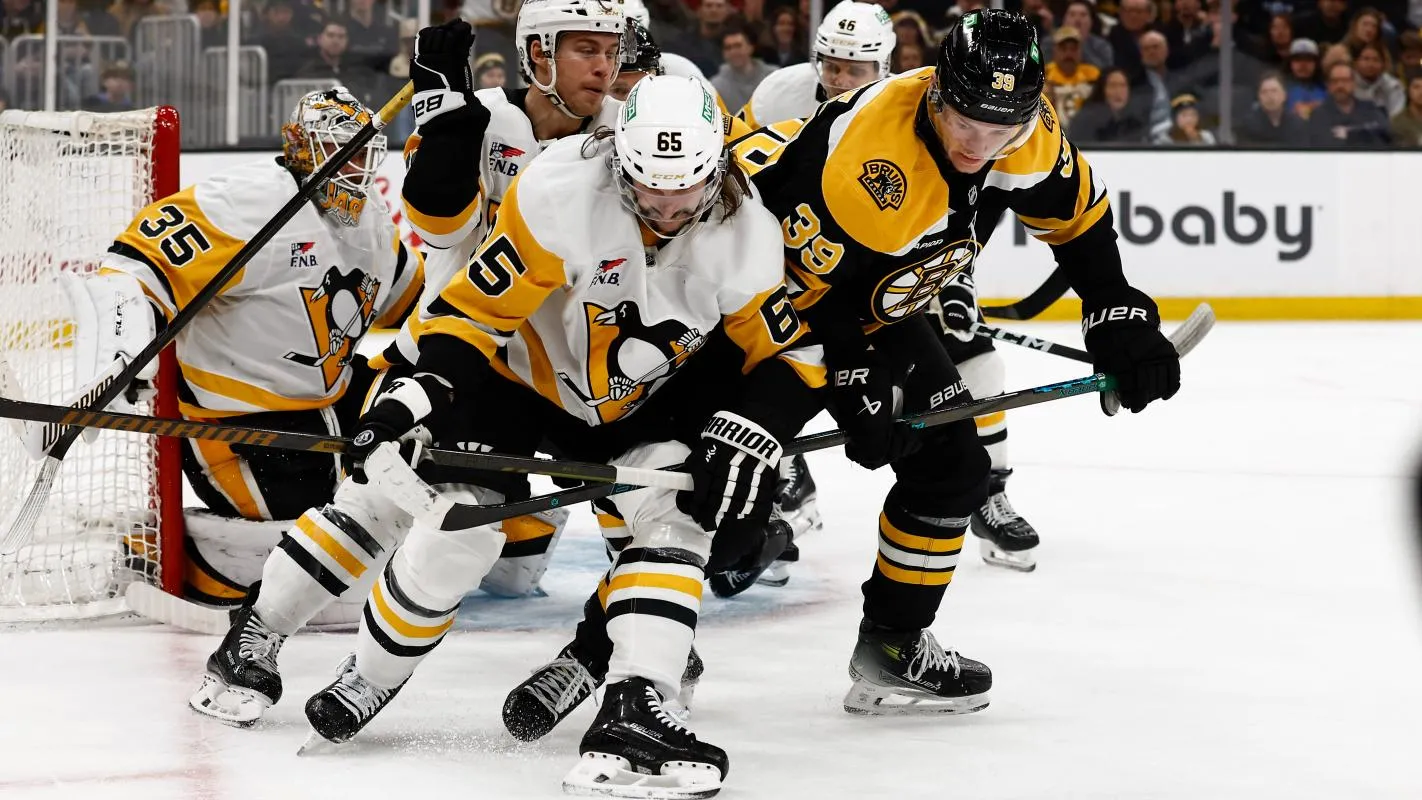 Pittsburgh Penguins defenseman Erik Karlsson (65) tries to hold off Boston Bruins center Morgan Geekie (39) from getting to the puck during the third period at TD Garden.