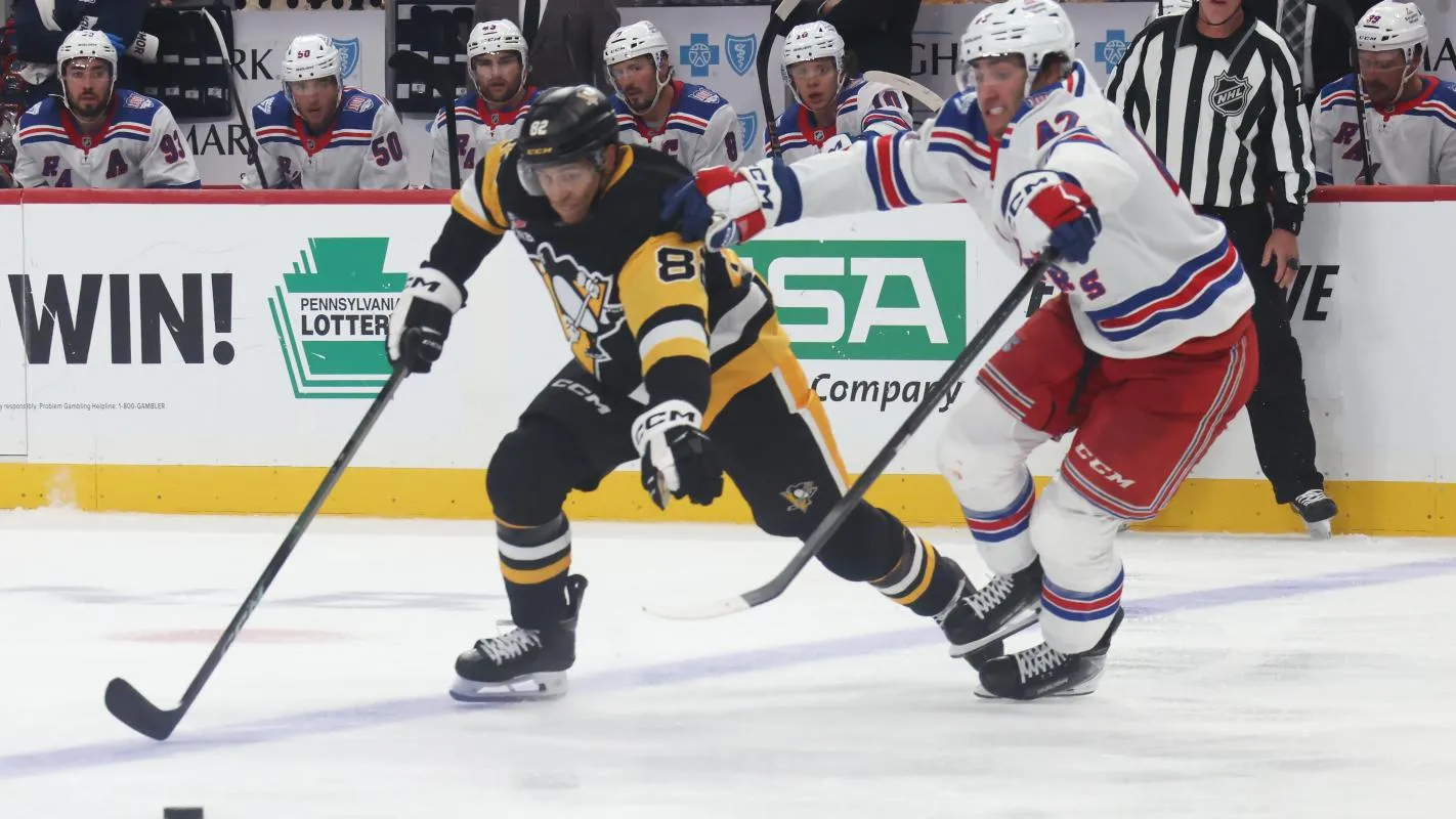 Pittsburgh Penguins defenseman Caleb Jones (82) chases the puck ahead of New York Rangers left wing Conor Sheary (43) during the third period at PPG Paints Arena.