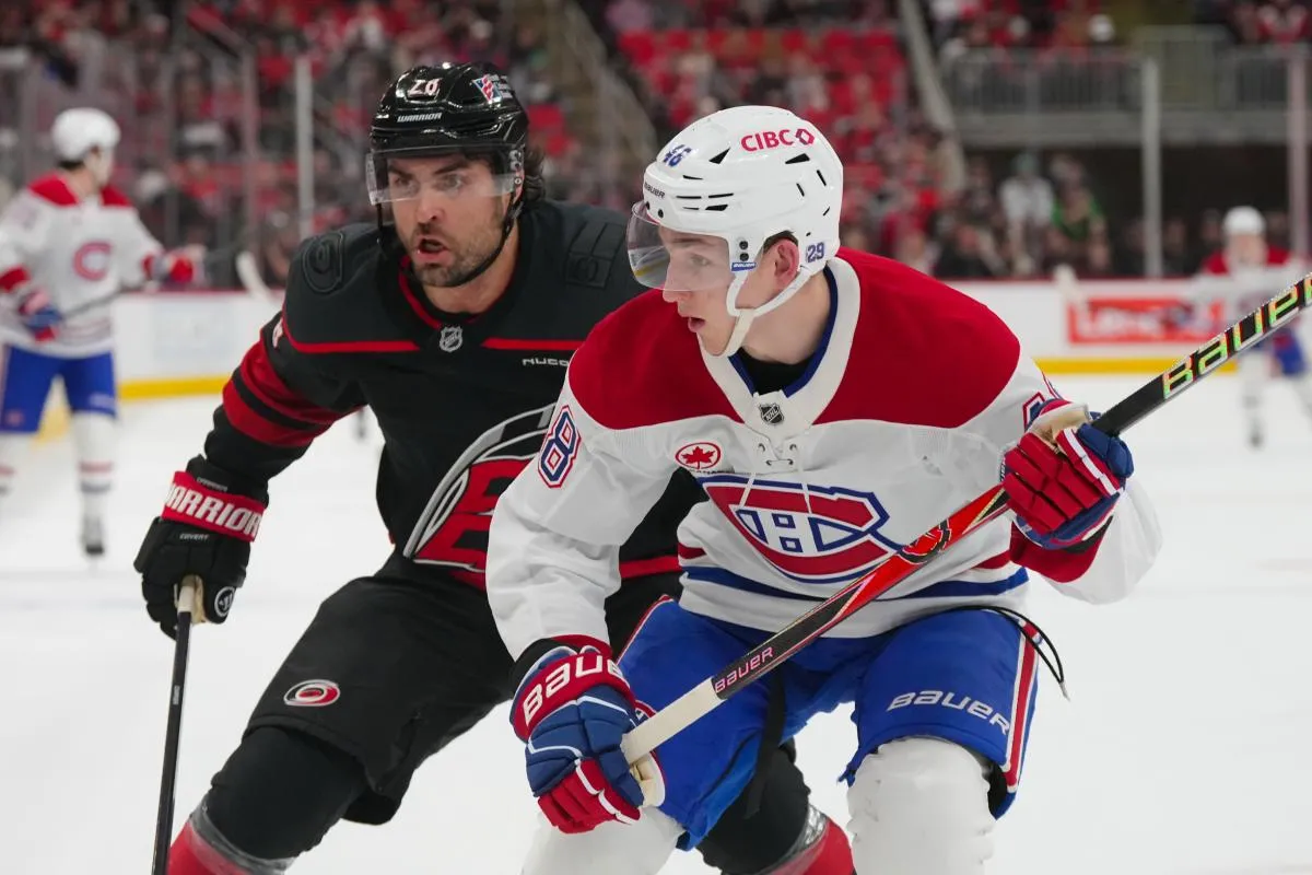 Le 1er janvier 2026, &agrave; Raleigh, en Caroline du Nord, aux &Eacute;tats-Unis, le d&eacute;fenseur des Canadiens de Montr&eacute;al, Lane Hutson (48), et l'ailier gauche des Hurricanes de la Caroline, William Carrier (28), se disputent la rondelle lors du premier tiers-temps au Lenovo Center.