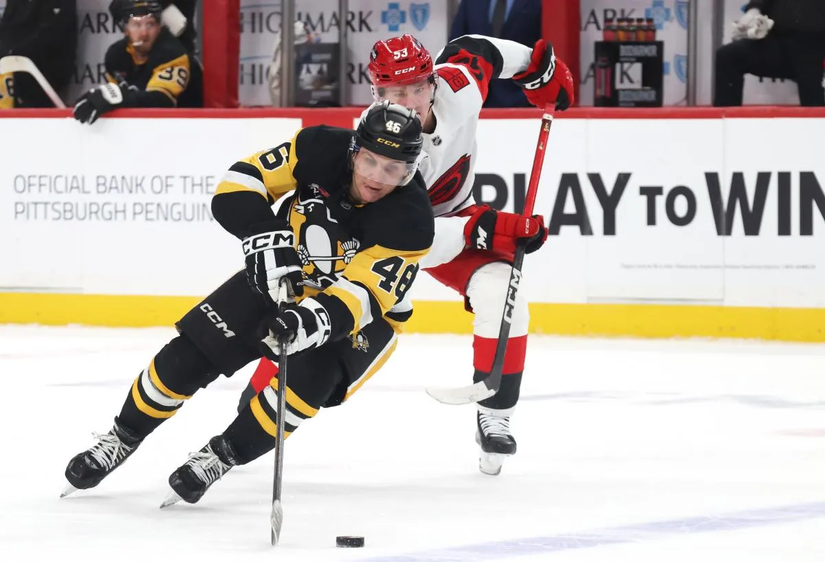 Pittsburgh Penguins center Blake Lizotte (46) moves the puck as Carolina Hurricanes right wing Jackson Blake (53) chases during the third period at PPG Paints Arena.