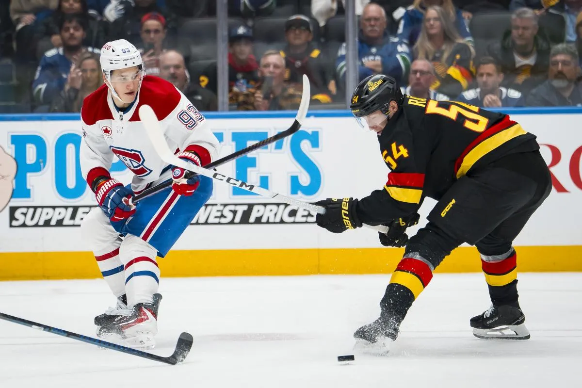 le joueur de hockey sur glace Aatu Raty (54) des Vancouver Canucks effectue une mise en &eacute;chec &agrave; l'aide de son b&acirc;ton sur le joueur de hockey sur glace Ivan Demidov (93) des Montr&eacute;al Canadiens, lors du troisi&egrave;me tiers-temps, &agrave; l'ar&eacute;na Rogers.