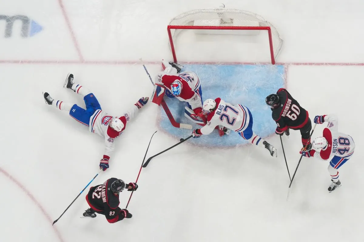 Le 1er janvier 2026, &agrave; Raleigh, en Caroline du Nord, aux &Eacute;tats-Unis, le centre des Hurricanes de la Caroline, Jesperi Kotkaniemi (82), tente un tir arr&ecirc;t&eacute; par le d&eacute;fenseur des Canadiens de Montr&eacute;al, Alexandre Carrier (45), le gardien de but, Jakub Dobes (75), et l'ailier gauche, Sammy Blais (27), lors de la deuxi&egrave;me p&eacute;riode au Lenovo Center.