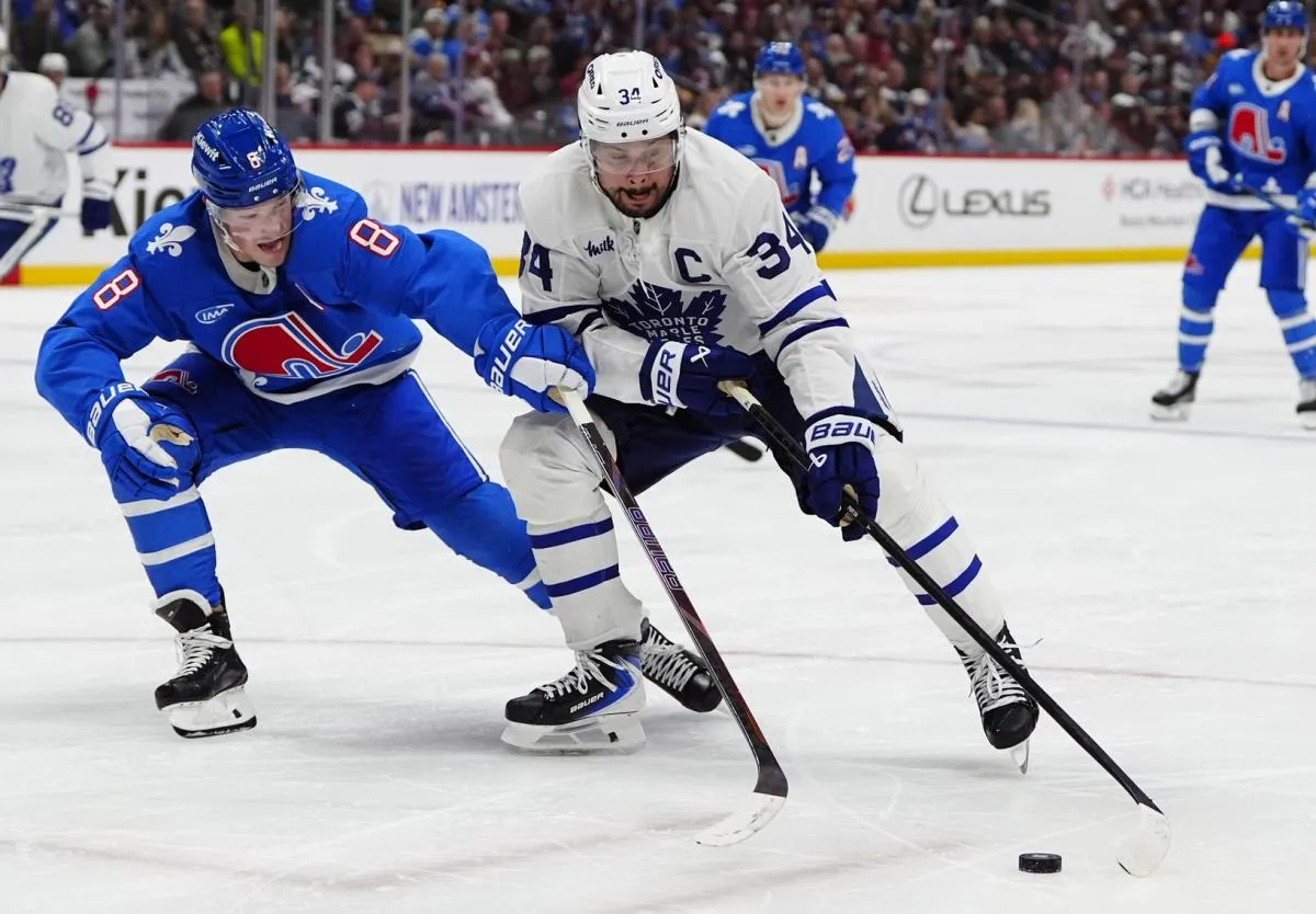 Toronto Maple Leafs center Auston Matthews (34) and Colorado Avalanche defenseman Cale Makar (8) battle for the puck in the third period at Ball Arena.