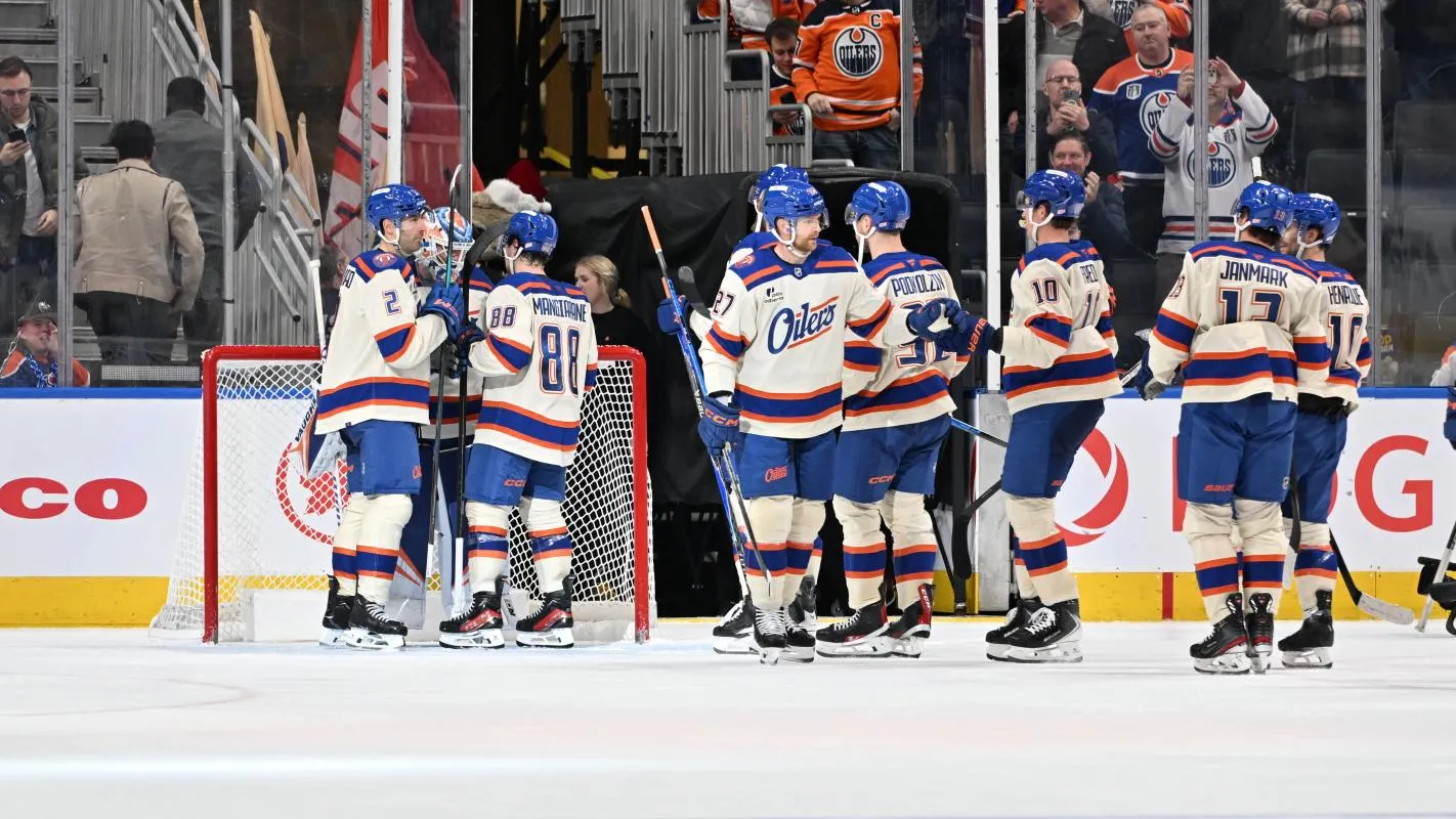Edmonton Oilers defenseman Evan Bouchard (2) with Oilers left winger Andrew Mangiapane (88) clebrates their win with Edmonton Oilers goalie Calvin Pickard (30) over the Seattle Kraken during the third period at Rogers Place.