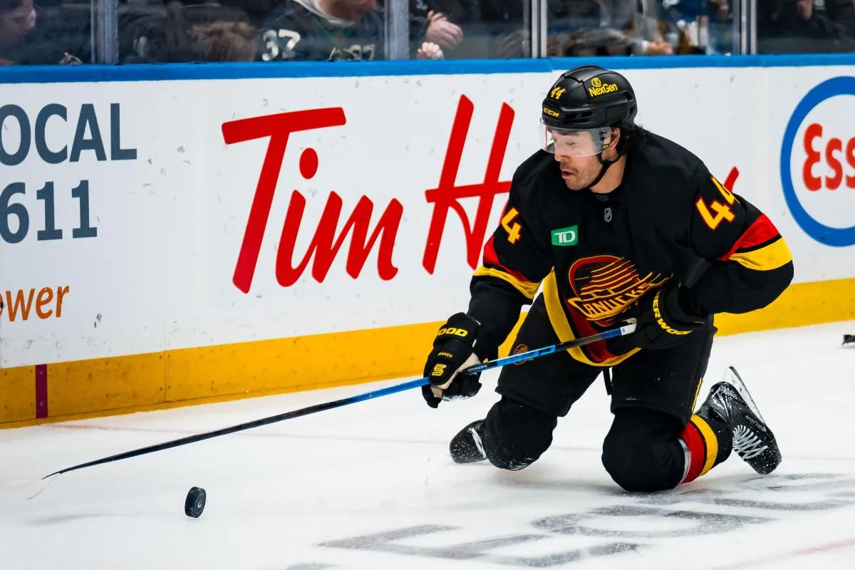 Vancouver Canucks forward Kiefer Sherwood (44) reaches for the loose puck against the Boston Bruins in the second period at Rogers Arena.