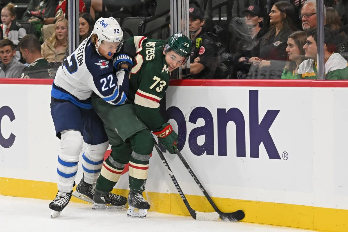 Winnipeg Jets forward Mason Appleton (22) and Minnesota Wild defenseman Kyle Masters (73) battle for the puck along the boards during the third period at Xcel Energy Center.