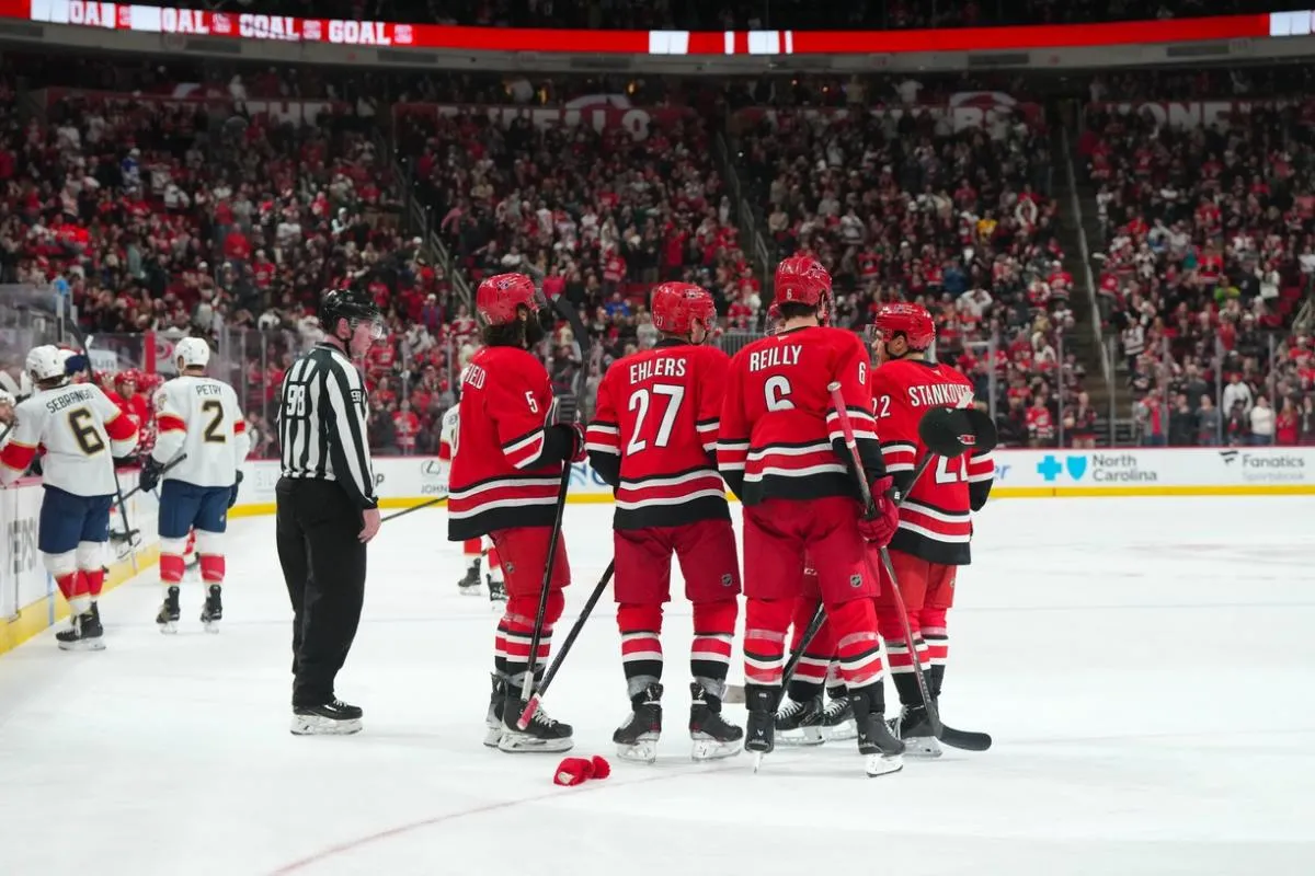 Carolina Hurricanes left wing Nikolaj Ehlers (27) is congratulated after his hat trick goal by defenseman Jalen Chatfield (5), defenseman Mike Reilly (6), center Logan Stankoven (22) and right wing Jackson Blake (53) against the Florida Panthers during the third period at Lenovo Center.