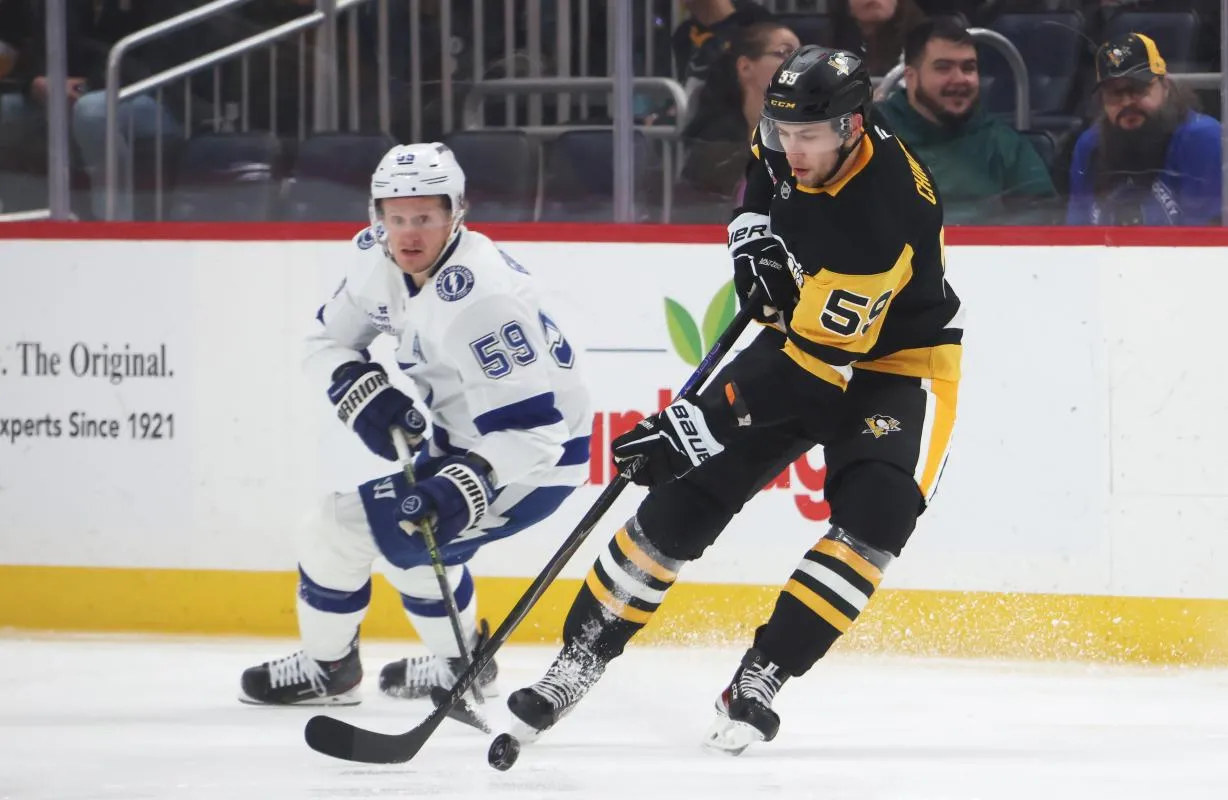 Pittsburgh Penguins right wing Egor Chinakhov (right) handles the puck against Tampa Bay Lightning center Jake Guentzel (left) during the second period at PPG Paints Arena.