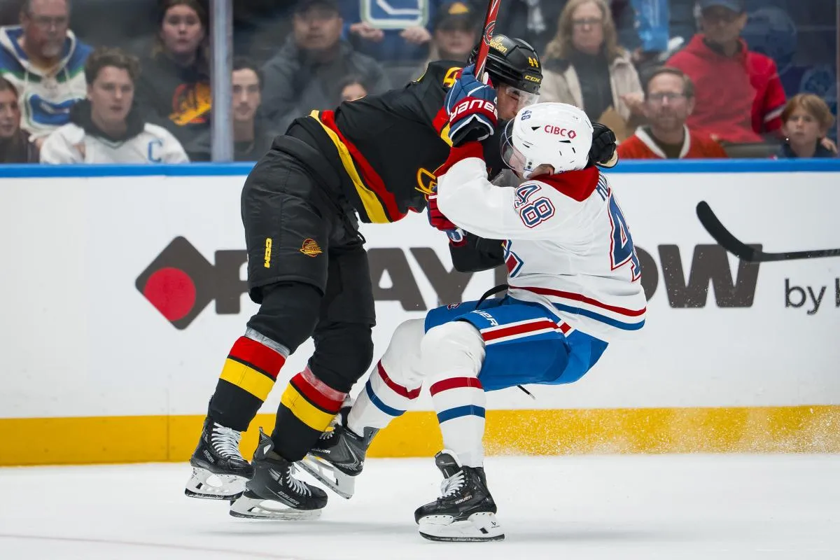 l'attaquant des Vancouver Canucks, Kiefer Sherwood (44), frappe le d&eacute;fenseur des Montr&eacute;al Canadiens, Lane Hutson (48), en deuxi&egrave;me p&eacute;riode, au Rogers Arena.