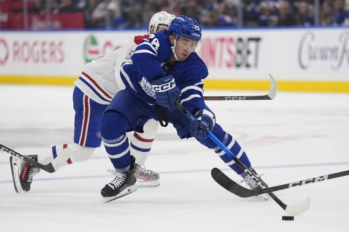 Toronto Maple Leafs defenseman Jacob Quillan (26) tries to control the puck against the Montreal Canadiens during the third period at Scotiabank Arena.