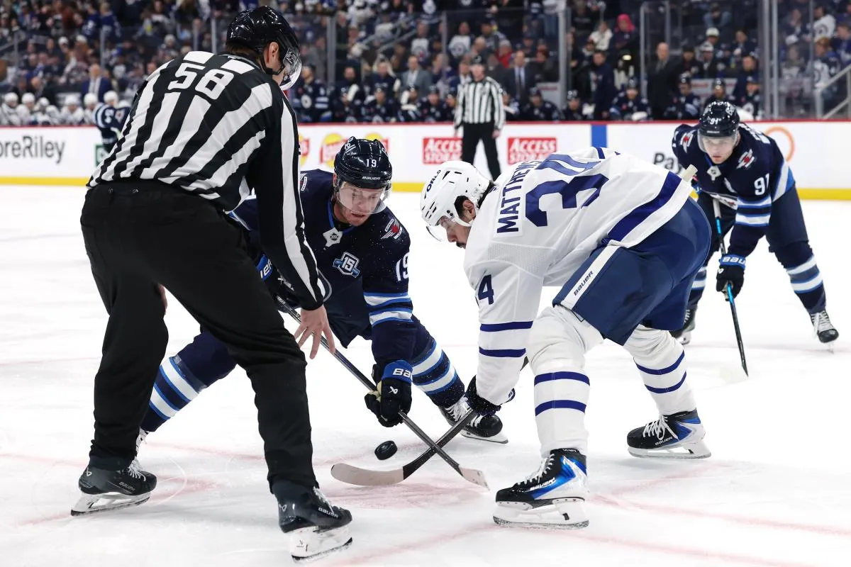 Winnipeg Jets center Jonathan Toews (19) and Toronto Maple Leafs center Auston Matthews (34) face off in the second period at Canada Life Centre.